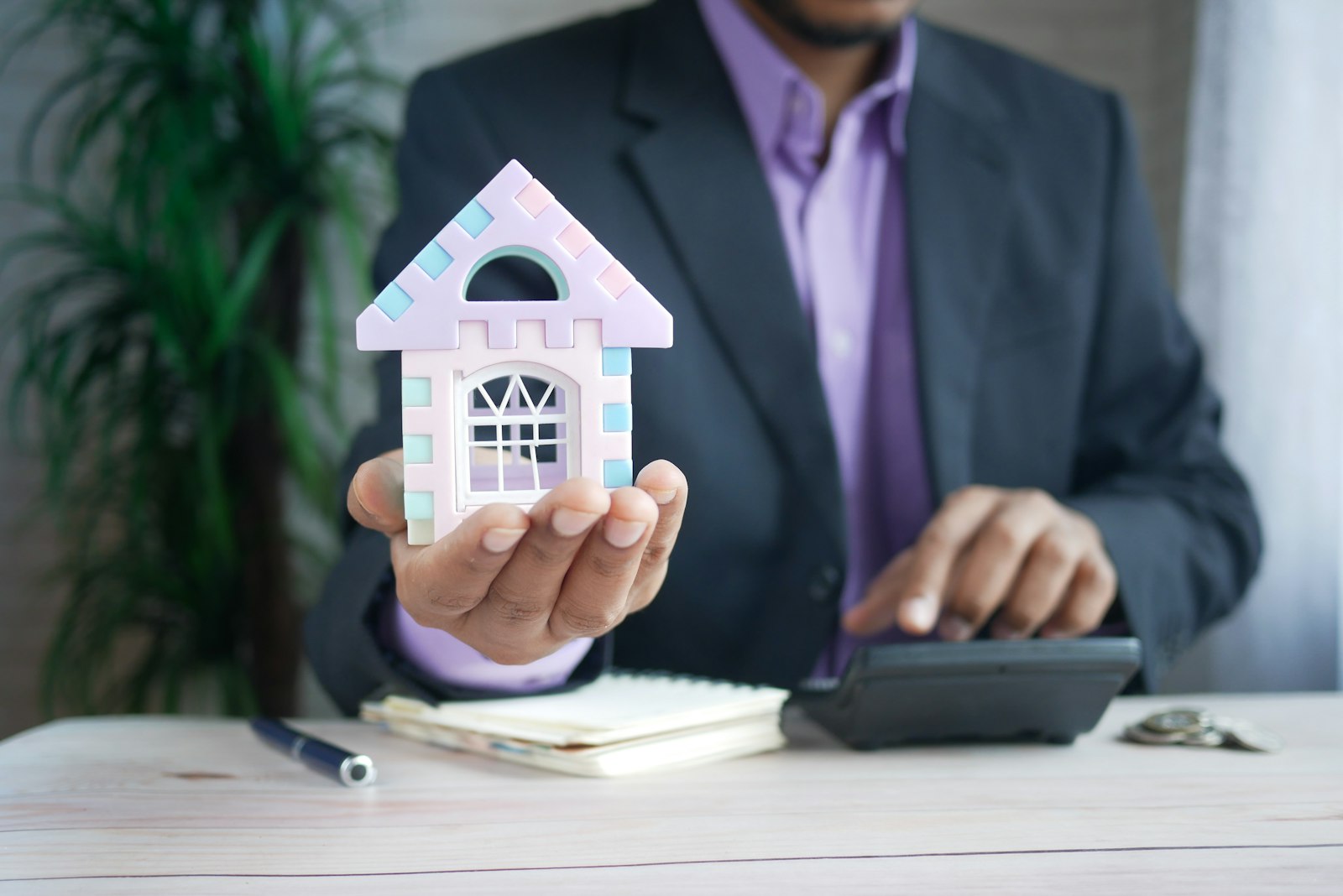 5 điều cần chuẩn bị trước khi xây nhà dành cho gia chủ 8 Người cầm mô hình nhà bên máy tính bỏ túi - lập ngân sách trước khi xây nhà